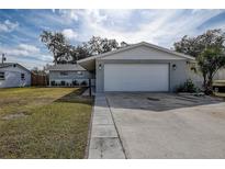 Newly renovated home with a landscaped lawn and a two-car garage at 5280 87Th N Ter, Pinellas Park, FL 33782