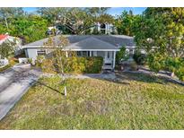 Single-story house with a spacious front yard and mature trees at 5971 52Nd N Ave, Kenneth City, FL 33709