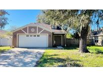 Cute one-story house with a white garage door and a spacious front yard at 7117 50Th E Ave, Palmetto, FL 34221