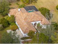 One-story home with pool and spa, surrounded by lush landscaping at 13315 Carnoustie Cir, Dade City, FL 33525