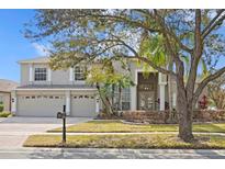 Charming two-story home featuring a three-car garage, a brick driveway, and mature landscaping at 16346 Ashington Park Dr, Tampa, FL 33647