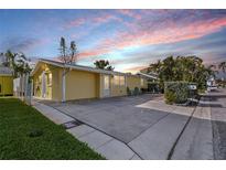 Charming one-story home with a spacious driveway and lush landscaping under a colorful sky at 18002 3Rd E St, Redington Shores, FL 33708