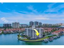 Aerial view of waterfront condo building with boat slips and city skyline at 240 Sand Key Estates Dr # 213, Clearwater, FL 33767
