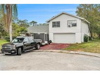 Detached garage with a large door and upper-level windows at 8018 Wildflower Row, Hudson, FL 34667
