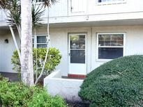 Exterior view of condo building showcasing landscaping and entrance at 946 Virginia St # 102, Dunedin, FL 34698