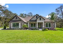 Attractive one-story home with stone accents and a landscaped lawn at 13458 Haflinger Way, Hudson, FL 34667