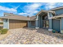 Attractive house exterior featuring a paver driveway and landscaping at 5052 Florentine Ct, Spring Hill, FL 34608