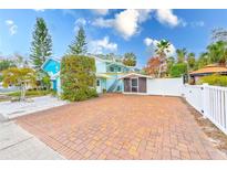 Brick driveway, white fence, and nicely landscaped yard at 604 Pennsylvania Ave, Crystal Beach, FL 34681