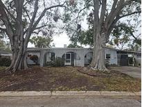 Ranch-style home with mature trees and a covered entryway at 6692 17Th N Way, St Petersburg, FL 33702