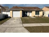 Cute one-story home with a brown roof, white garage door, and well-maintained lawn at 1915 Crown Park Dr, Valrico, FL 33594
