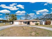 Tan single-story home with a carport and a spacious lawn at 2533 Duncan Dr, Belleair Bluffs, FL 33770