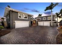 Two-story home with two 2-car garages, a large brick driveway, palm trees and well-manicured landscaping at 2785 Bayside S Dr, St Petersburg, FL 33705