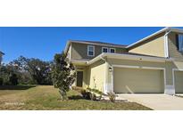 Two-story townhome with attached garage and landscaped front yard at 2933 Jacob Crossing Ln, Holiday, FL 34691