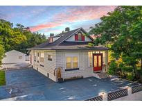 Charming bungalow with a white brick exterior and red front door at 3105 W Spruce St, Tampa, FL 33607