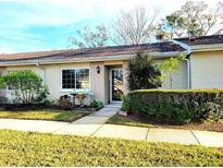 Attractive exterior of a light beige single-story home with well-manicured landscaping at 1000 Dunrobin Dr # C, Palm Harbor, FL 34684