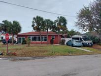 Red house with palm trees and driveway, located on a corner lot at 15806 Redington Dr, Redington Beach, FL 33708