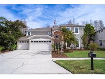 Two-story house with a three-car garage and landscaped yard at 18809 Chaville Rd, Lutz, FL 33558