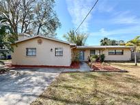 Ranch-style home with landscaped yard and driveway at 400 Country Club Dr, Oldsmar, FL 34677