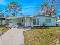 Cute teal house with a carport and well-manicured lawn at 404 Manor Blvd, Palm Harbor, FL 34683