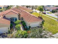 Attractive home with tile roof, two-car garage, and lush landscaping at 4935 Marble Springs Cir, Wimauma, FL 33598