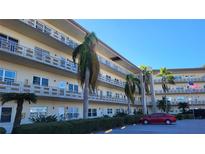 Two-story condo building with palm trees and a red car in the parking lot at 5725 80Th N St # 314, St Petersburg, FL 33709