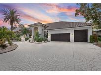 Luxury home with circular driveway, lush landscaping, and captivating sunset views at 5801 Leeland S St, St Petersburg, FL 33715