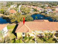 Aerial view of condo building near lake, showing property location and community amenities at 6816 Dali Ave # E206, Land O Lakes, FL 34637