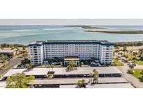 Aerial view of a waterfront condo building with parking and beautiful water views at 7 Elgin Pl # 701, Dunedin, FL 34698