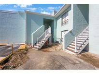 Two-story building with stairs leading to condo entrances at 1 Windrush Blvd # 100, Indian Rocks Beach, FL 33785