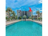 Resort-style pool and building exterior with lush landscaping at 19725 Gulf Blvd # 405, Indian Shores, FL 33785