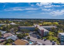 Aerial view of a condo building with a pool and surrounding landscape at 2363 Israeli Dr # 61, Clearwater, FL 33763