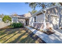 Tan house with stone accents, walkway, and two-car garage at 354 Ixora Dr, Palm Harbor, FL 34684