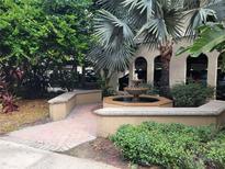 Beautiful courtyard featuring a fountain, palm trees, and lush greenery at 501 Knights Run Ave # 1113, Tampa, FL 33602