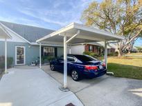 Carport with a blue sedan parked underneath, located in front of a light-blue house at 6103 Elmhurst Dr, New Port Richey, FL 34653