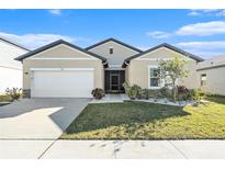 Single-story home with two-car garage and landscaped lawn at 732 Ocean Spray Dr, Ruskin, FL 33570