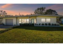 Updated mid-century modern home with a spacious lawn and attached garage at 11388 77Th Ave, Seminole, FL 33772