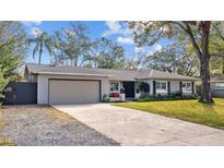 Updated single-story home with attractive landscaping and a two-car garage at 12717 Carte Dr, Tampa, FL 33618