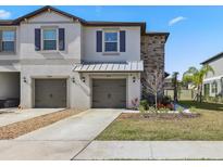 Two-story townhome with two-car garage and landscaped front yard at 14341 Editors Note St, Ruskin, FL 33573