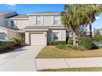 Two-story tan house with white shutters, a garage, and landscaping at 14935 Skip Jack Loop # 106, Lakewood Ranch, FL 34202