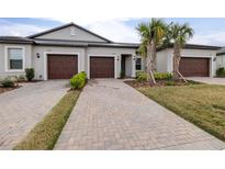 Two-car garage, light gray exterior, and a brick paver driveway at 31349 Cabana Rye Ave, San Antonio, FL 33576