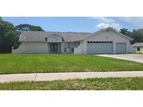 One-story house with a two-car garage and a large front yard at 3385 Spring Park Way, Brooksville, FL 34604