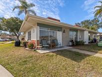 Exterior view of a mid-century modern home with a landscaped lawn at 4316 Tahitian Gardens Cir # H, Holiday, FL 34691