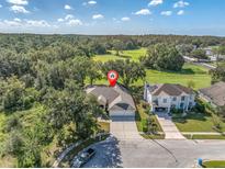 Aerial view of a house with a three-car garage and a large backyard at 4996 Felecity Way, Palm Harbor, FL 34685