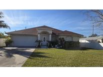 Single-story house with a red tile roof, attached garage, and well-maintained lawn at 6190 107Th N Ave, Pinellas Park, FL 33782