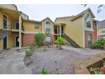 Exterior view of a two-story condo building with brick and siding at 8609 Mallard Reserve Dr # 103, Tampa, FL 33614