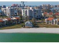 Aerial view of waterfront home with beach access and city skyline in background at 887 S Gulfview Blvd, Clearwater Beach, FL 33767