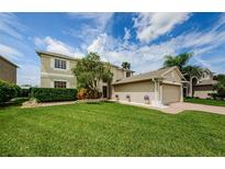 Two-story house with attached garage, landscaping, and a spacious lawn at 1553 Regal Mist Loop, Trinity, FL 34655