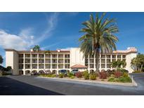 Multi-story building with a well-maintained landscaped front and ample parking spaces on a sunny day at 19029 Us Highway 19 N # 26-206, Clearwater, FL 33764