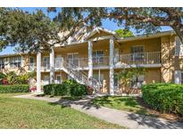 Two-story condo building with lush landscaping and a walkway at 2112 Gulf View Blvd, Dunedin, FL 34698