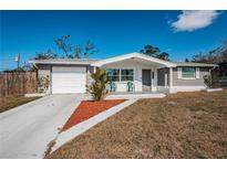 Charming single-story home with a well-maintained lawn and inviting front porch seating at 5405 Golden Nugget Dr, Holiday, FL 34690